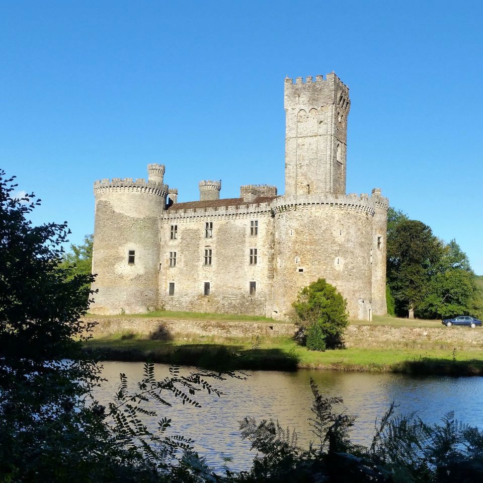 Chateau Montbron Chateau Montbron on an island with a tall square tower, blue skies and surrounded by trees