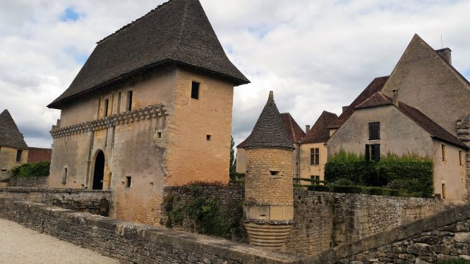Chateau de Losse Bridge thriugh high rooves stone building to the castletety