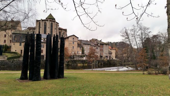 Saint Leonard de Noblat Saint Leonard de Noblat showing the ancient village by the river with 6 tall statues on the grass