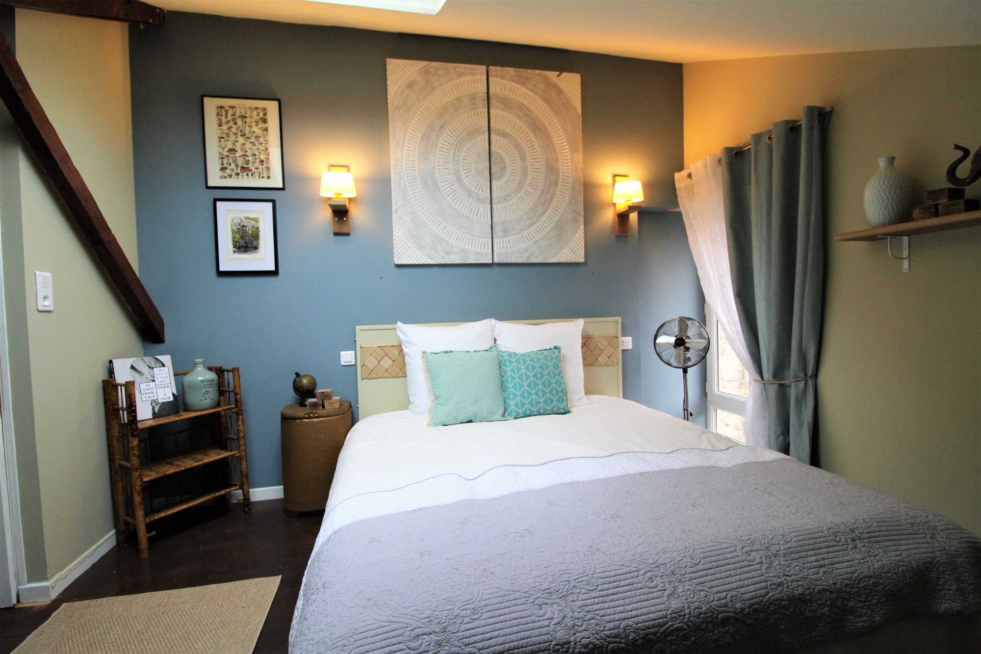 Gite blue bedroom with kingsize bed A neatly made bed with a pretty blue cushions, creating a serene and inviting atmosphere.