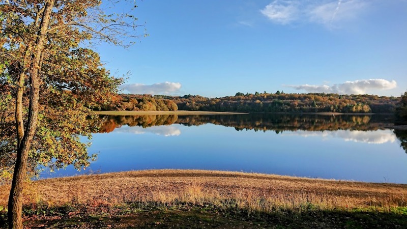 Autumn view of the Barrage de Mialet with trees reflecting in the water