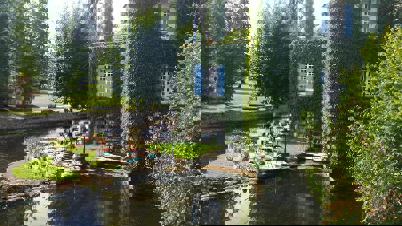 The terrace of Le Moulin de l'Abbaye Michelin-starred restaurant overlooking the River Dronne and Pont Coudé bridge, Brantôme