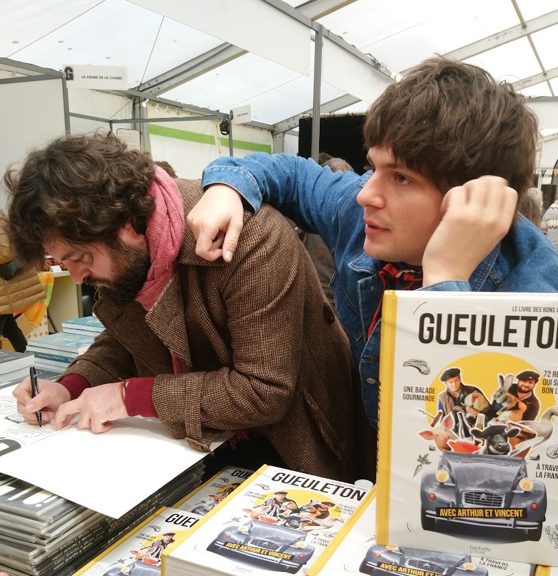 Cookbook festival Perigueuex Male sitting at table waiting to sign his book