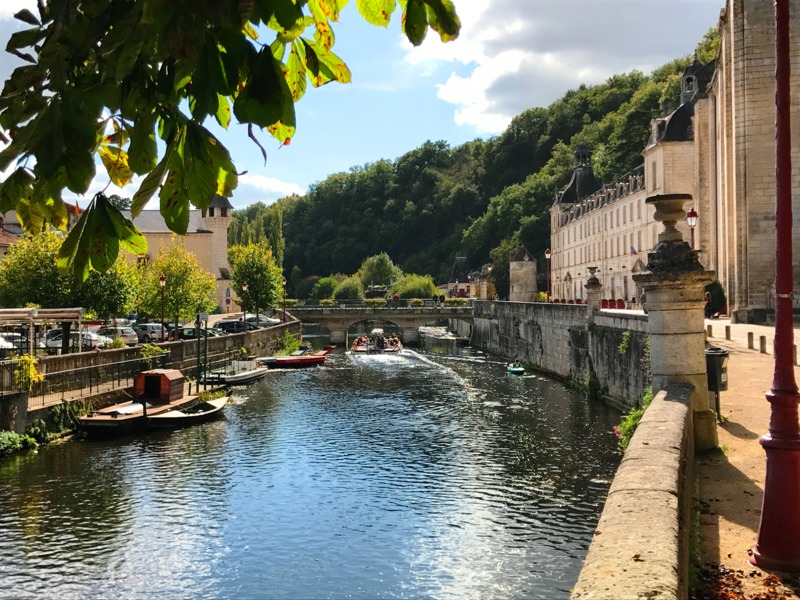 The River Dronne flowing through Brantôme with weeping willows and medieval stone buildings, Périgord Vert