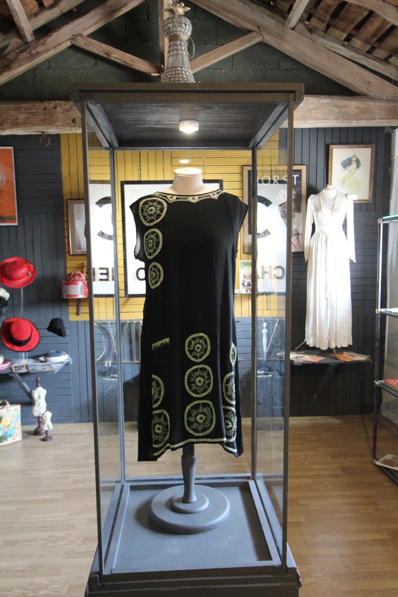 Flapper dress wth neads in side a glass case in the fashion museum at Your French Stay