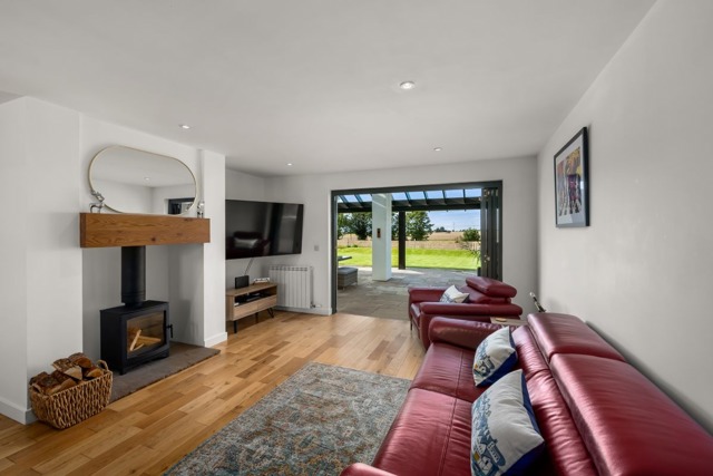 open plan living room with log burner and comfortable leather sofas
