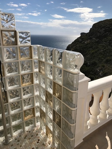 Glass brick pool shower with views to the sea and mountain