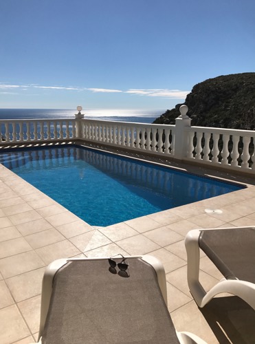 Sun loungers by the pool with a sea view