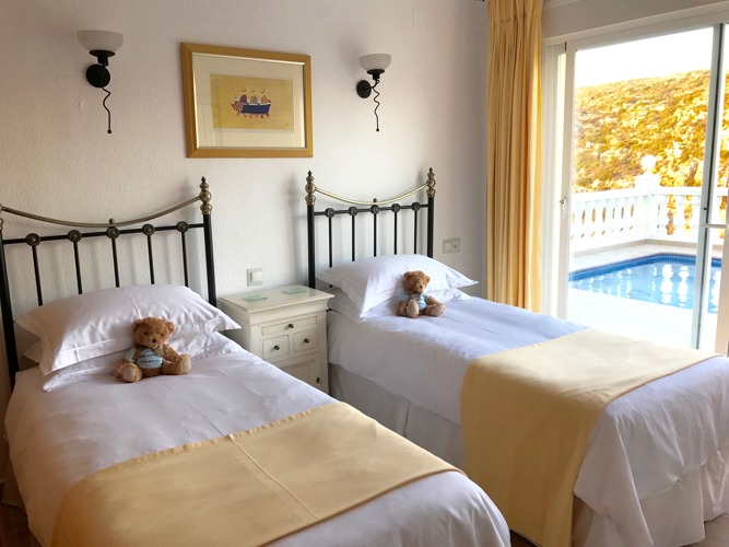 Twin bedded room with glass doors to the pool terrace