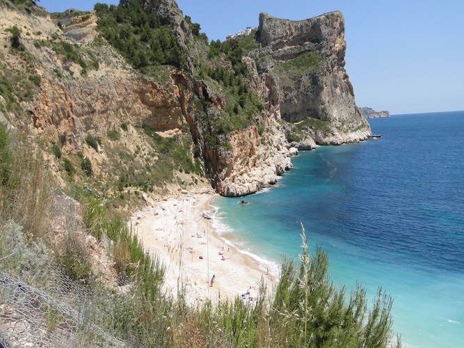 Cala del Moraig beach at Cumbre del Sol, where dramatic cliffs surround the picturesque beach