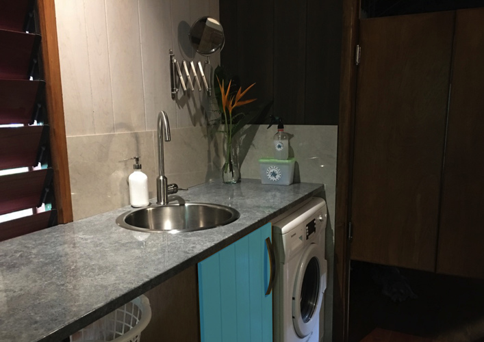Modern laundry/wet room with 5 kg washing machine & heaps of bench space.