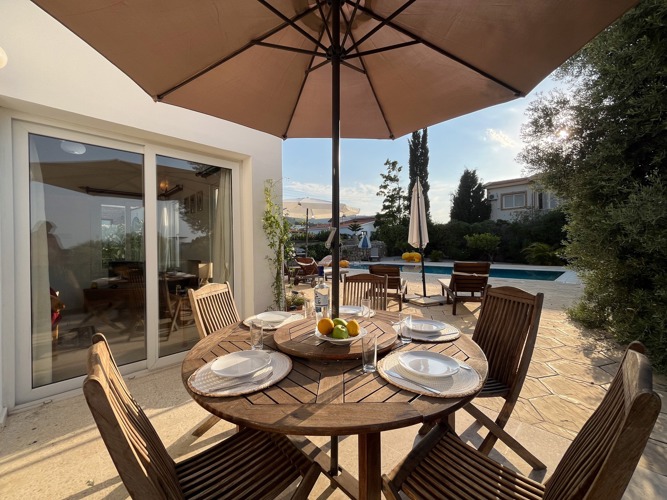 Outdoor dining table under a parasol with mountain views