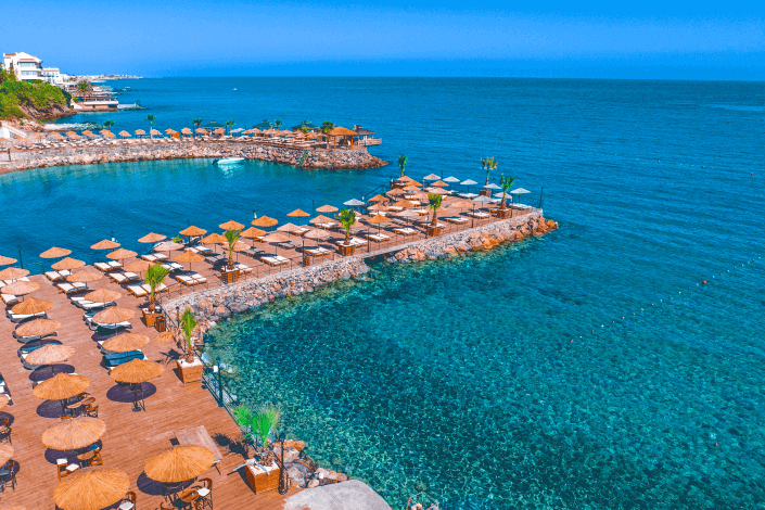 Sun loungers and parasols beside turquoise water on the Lapta coast