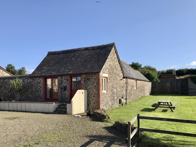 Front view of The long Barn with the un-enclosed side garden to the right